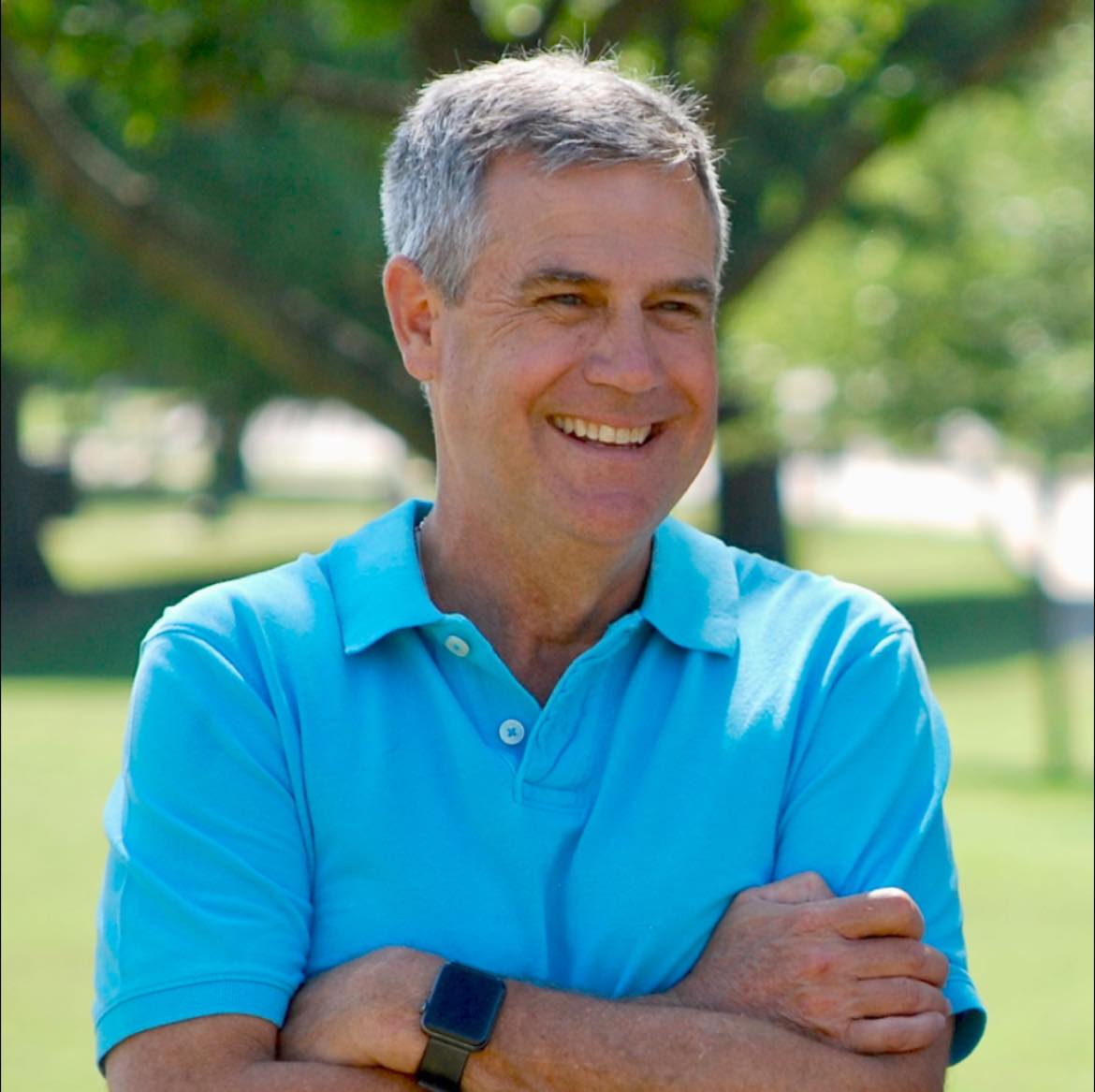 Greg Porter in front of grassy and treed background.